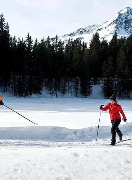 A couple cross-country skiing on a freshly prepared trail.