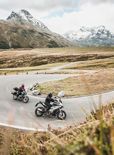 Zwei Motoradfahrer fahren eine kurvige Straße.