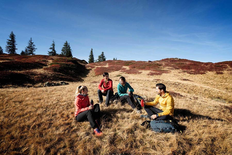 Pause machende Wandergruppe bei deren Herbstwanderung aufs Muttjöchle am Kristberg im Silbertal